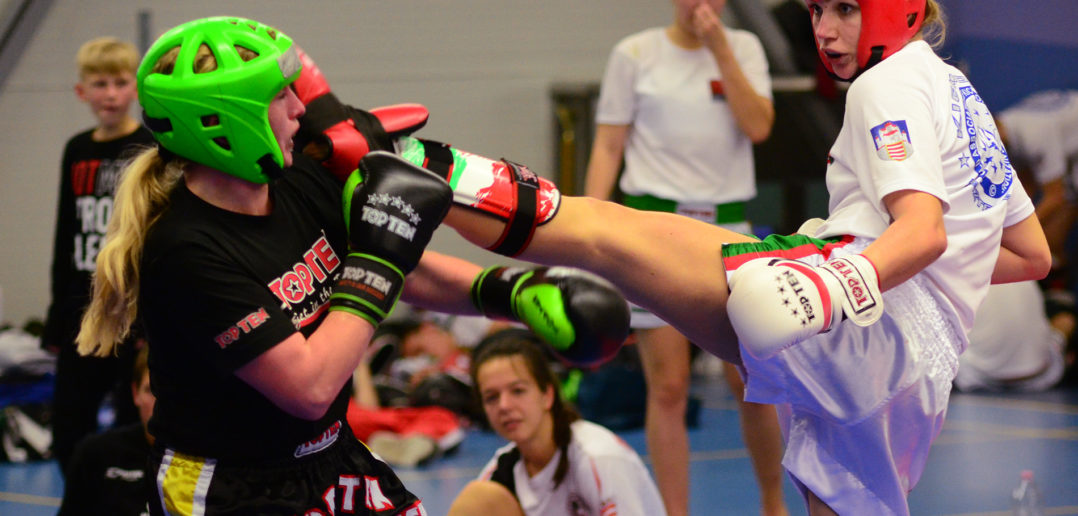 Kick-light competition during a kickboxing tournament in Prague where a Slovakian woman attacks her Austrian opponent with an axe kick.